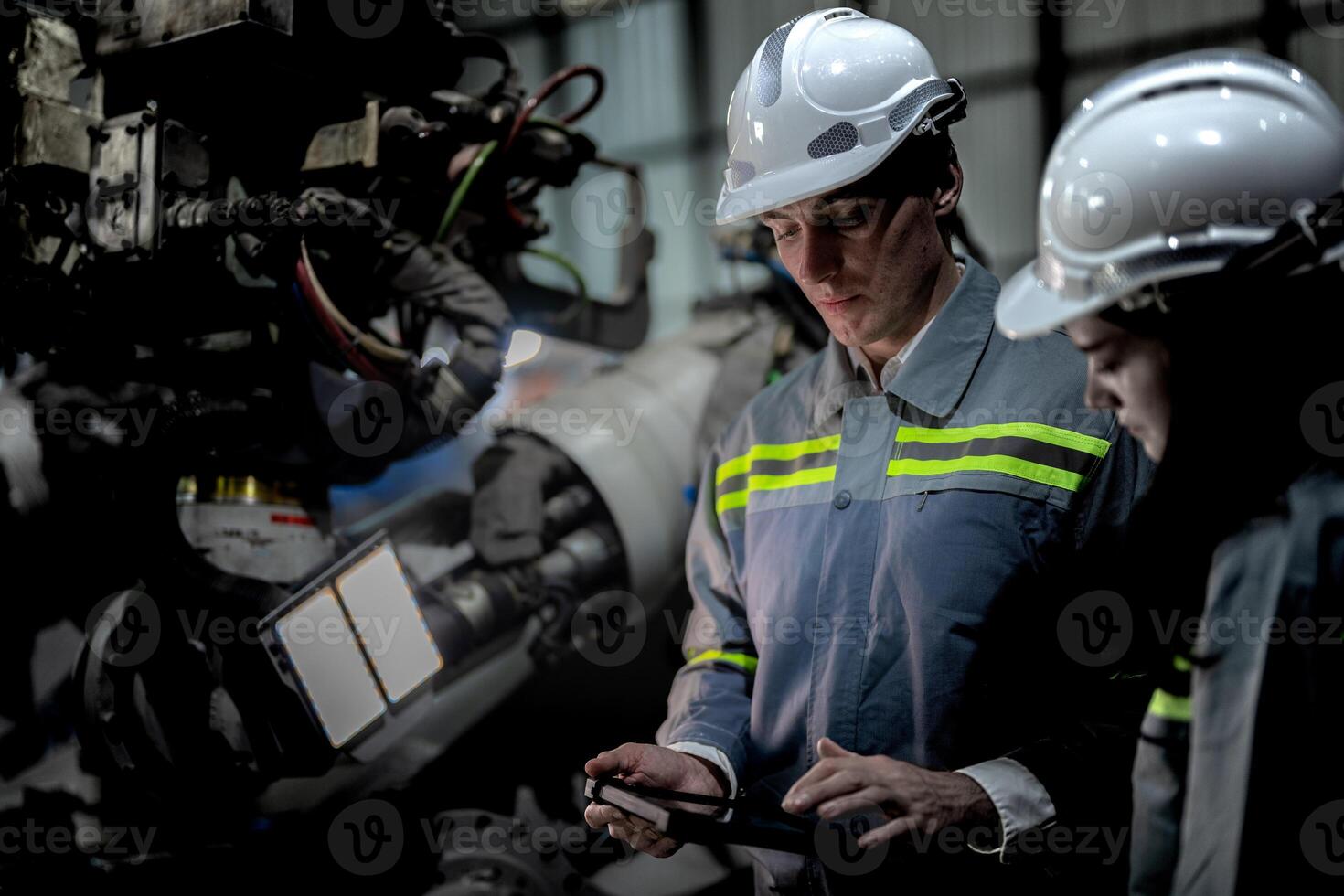 ingenieurs controleren controle zwaar machine robot arm. verschillend team van industrieel robotica ingenieurs verzameld in de omgeving van machine. professioneel machinerie operators reparatie elektrisch robot Aan helder digitaal paneel. foto