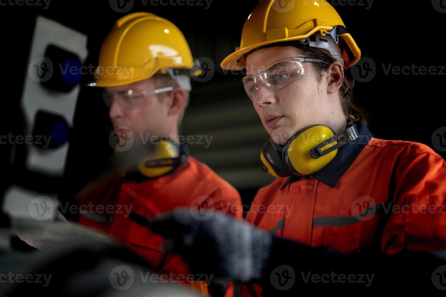 ingenieur Mens controle de toestand van machine en gebruikt moersleutel naar schroef sommige een deel van uitrusting Bij cnc fabriek. arbeider vervelend veiligheid bril en helm. onderhoud en repareren concept. foto