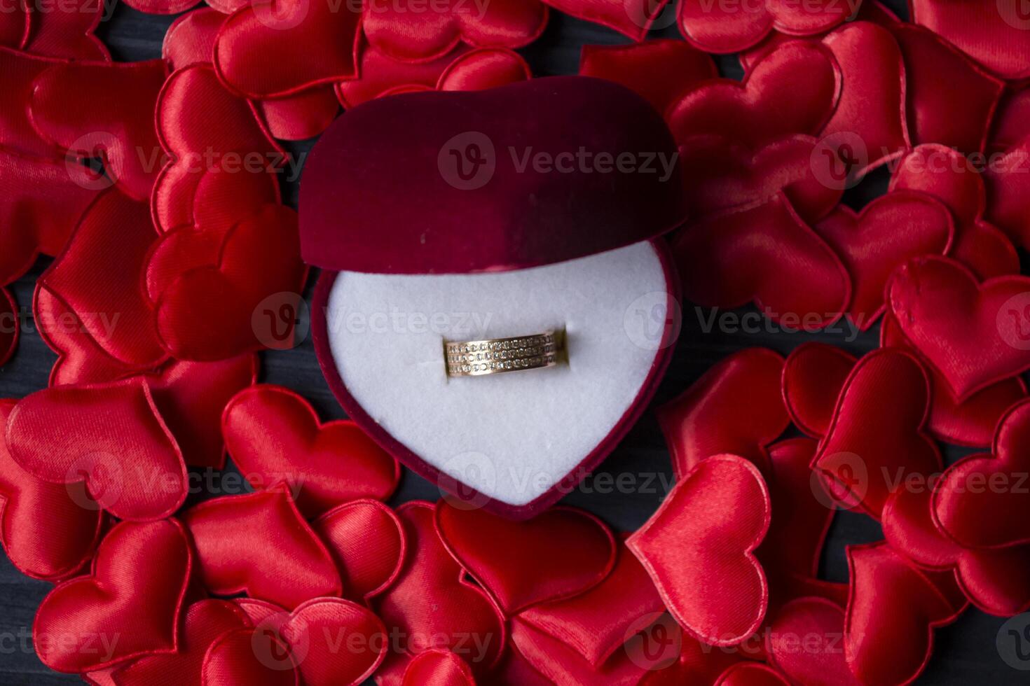 verloving ring in een rood doos Aan een liefde harten achtergrond. foto