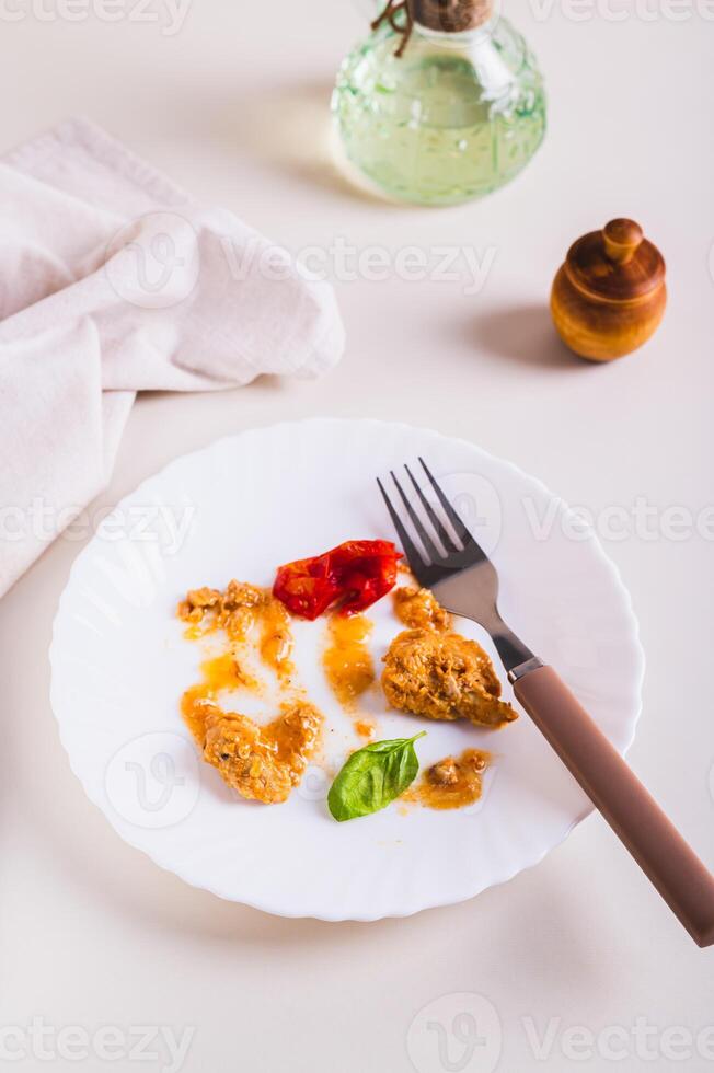 voedsel verspilling en bestek Aan een vuil bord Aan de tafel verticaal visie foto