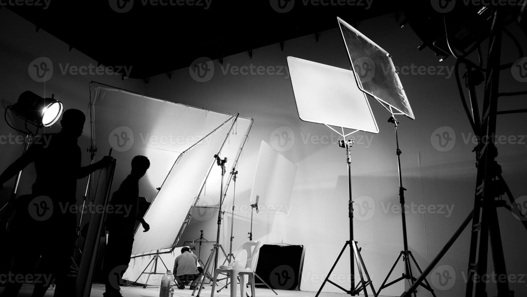 silhouet van video productie achter de scènes of b rollen of maken van TV reclame film dat film bemanning team licht man en cameraman werken samen met regisseur in groot studio met pro uitrustingen foto