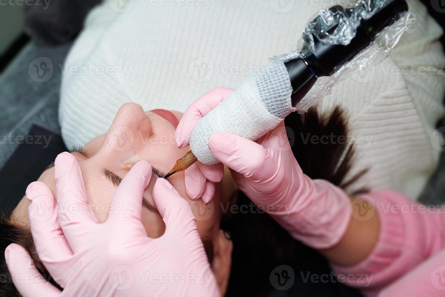 de meester presteert de procedure van blijvend bedenken tussen de wimpers. blijvend oog bedenken en pmu wimpers foto