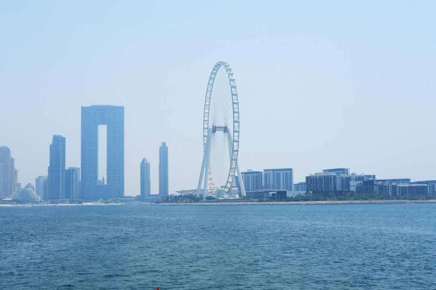 helder dag visie van van Dubai horizon en zee, symboliseert economisch uitbreiding en kans. dubai, uae - augustus 15, 2023 foto