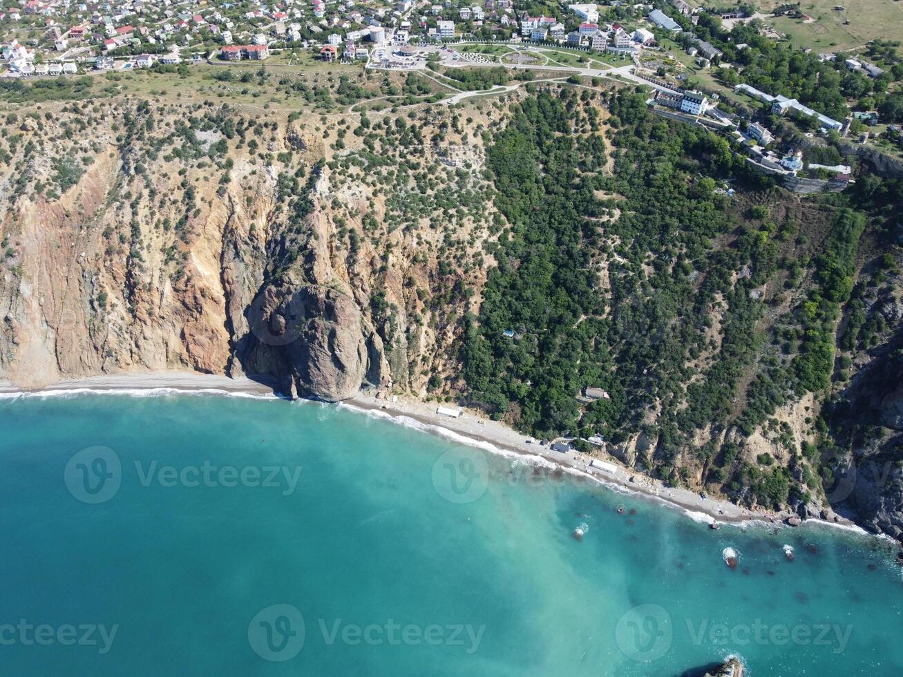 antenne visie van bovenstaand Aan kalmte azuur zee en vulkanisch rotsachtig oevers. klein golven Aan water oppervlakte in beweging vervagen. natuur zomer oceaan zee strand achtergrond. niemand. vakantie, vakantie en reizen concept foto