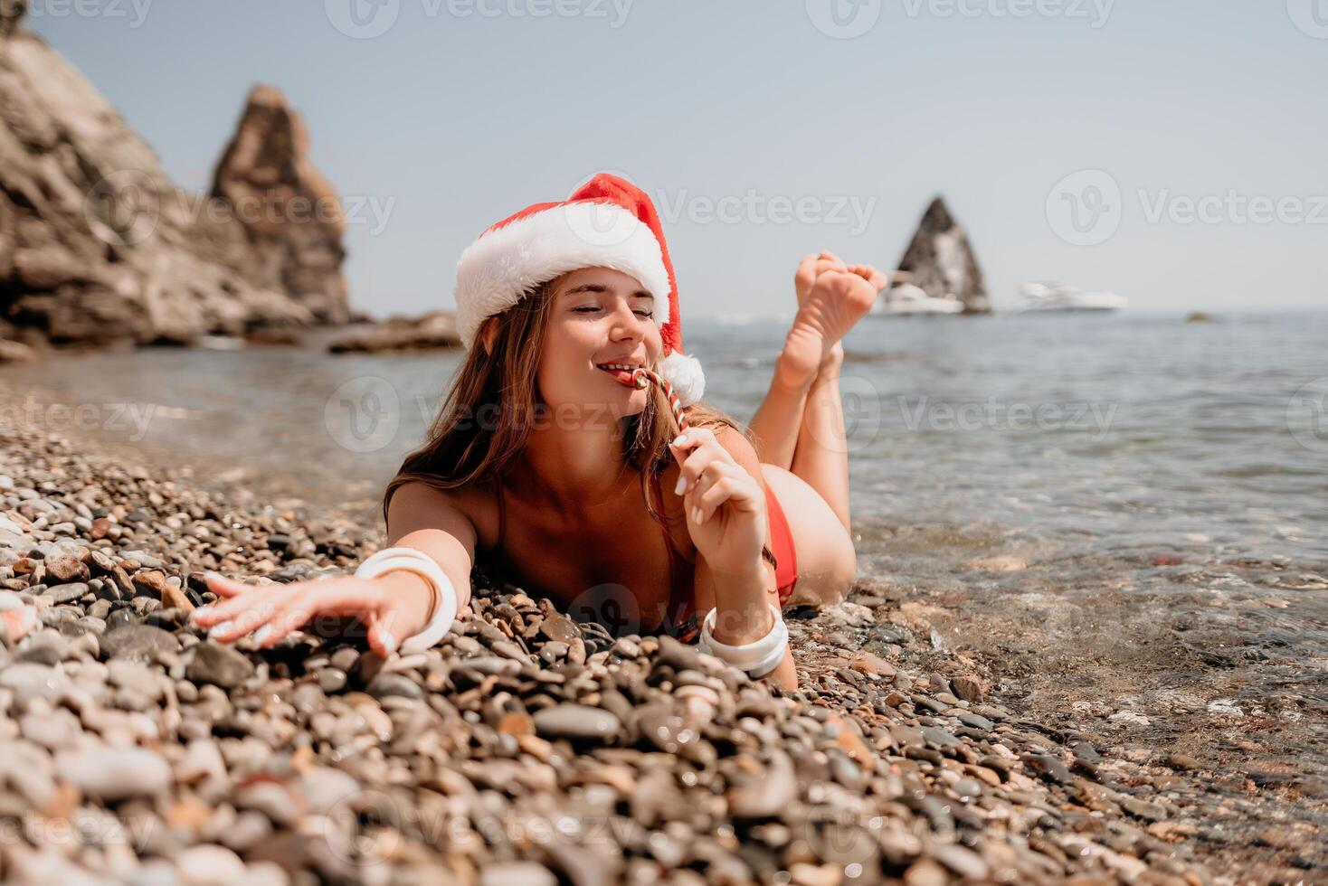 vrouw reizen zee. gelukkig toerist genieten nemen afbeelding Aan de strand voor herinneringen. vrouw reiziger in de kerstman hoed looks Bij camera Aan de zee baai, sharing reizen avontuur reis foto