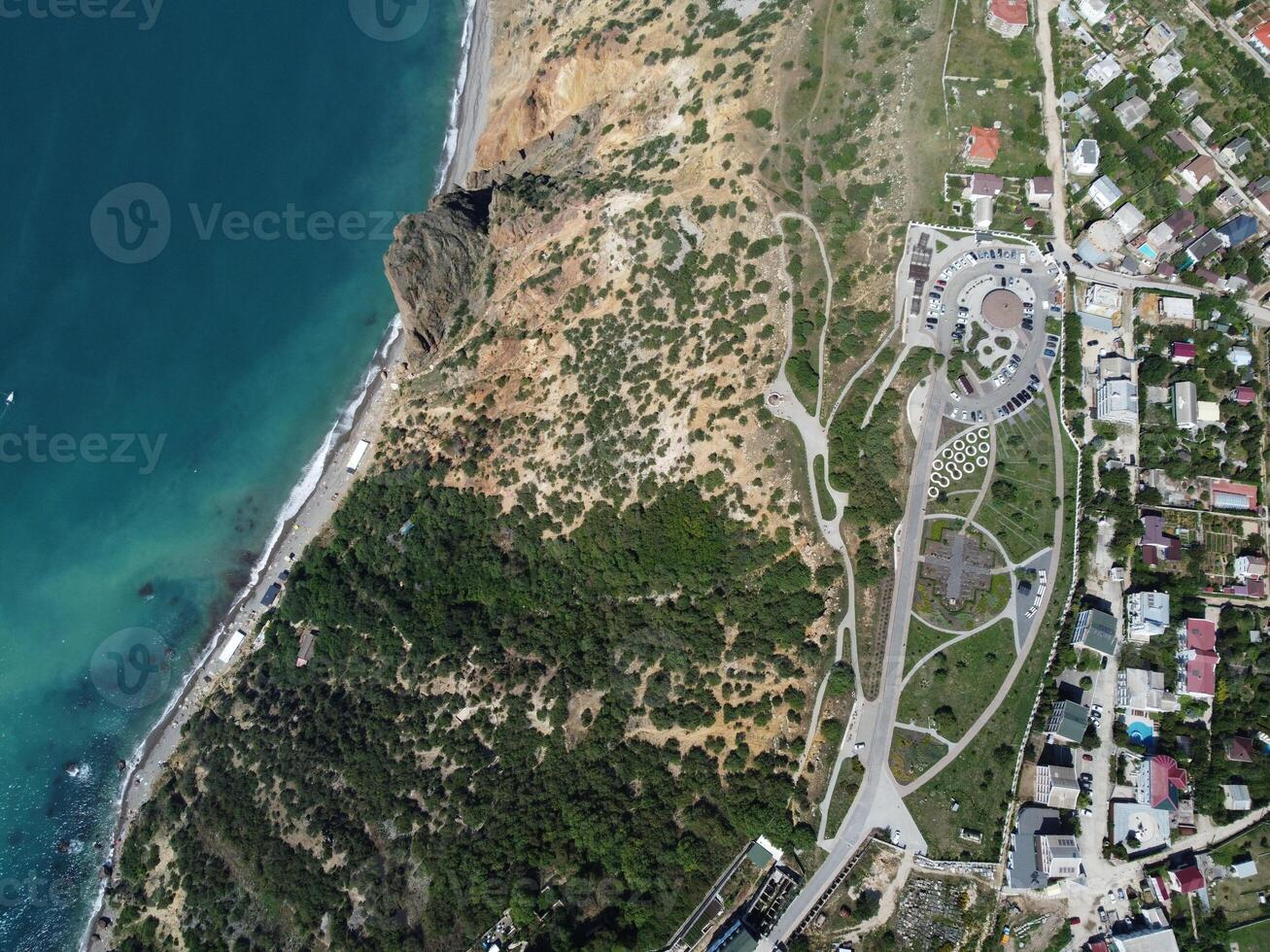 antenne visie van bovenstaand Aan kalmte azuur zee en vulkanisch rotsachtig oevers. klein golven Aan water oppervlakte in beweging vervagen. natuur zomer oceaan zee strand achtergrond. niemand. vakantie, vakantie en reizen concept foto