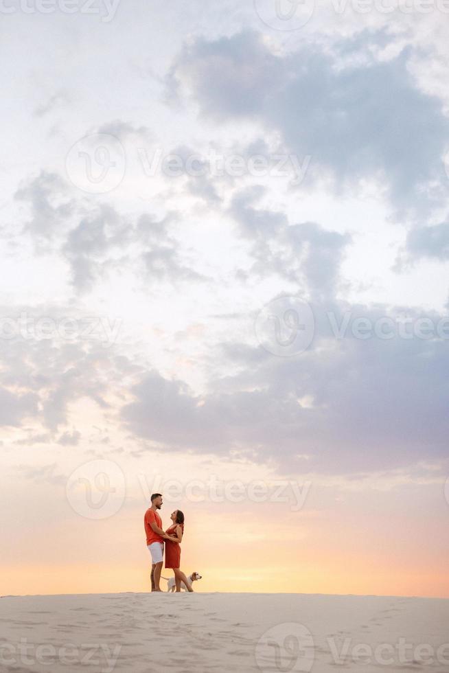 jong stel in oranje kleren met hond foto