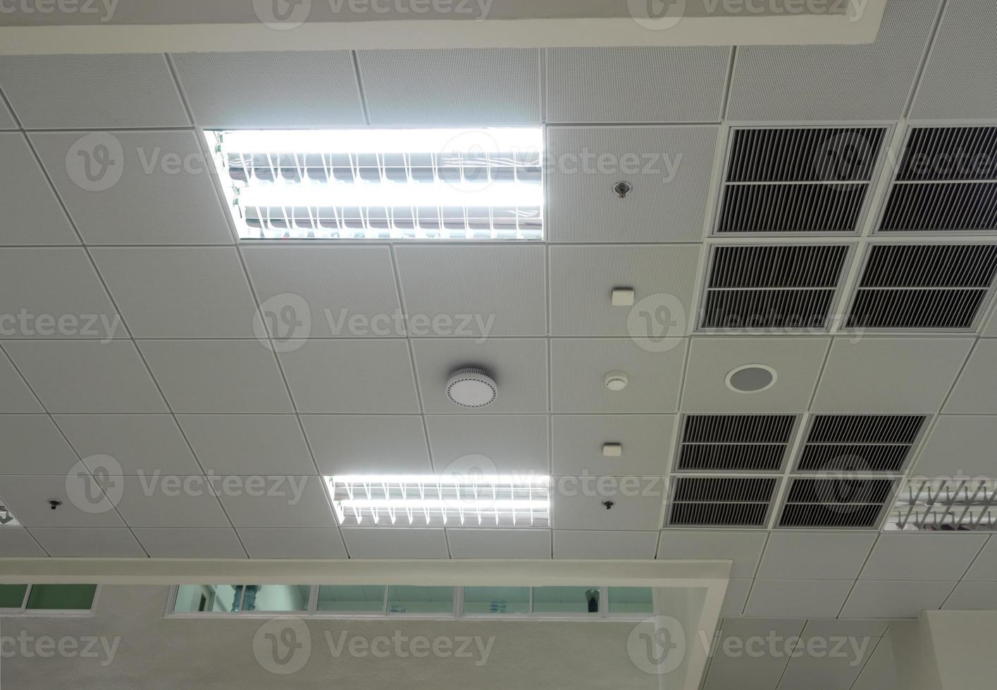 airconditioningmasker, verlichting en moderne apparatuur aan het plafond, geselecteerde verlichting uitschakelen voor energiebesparing foto