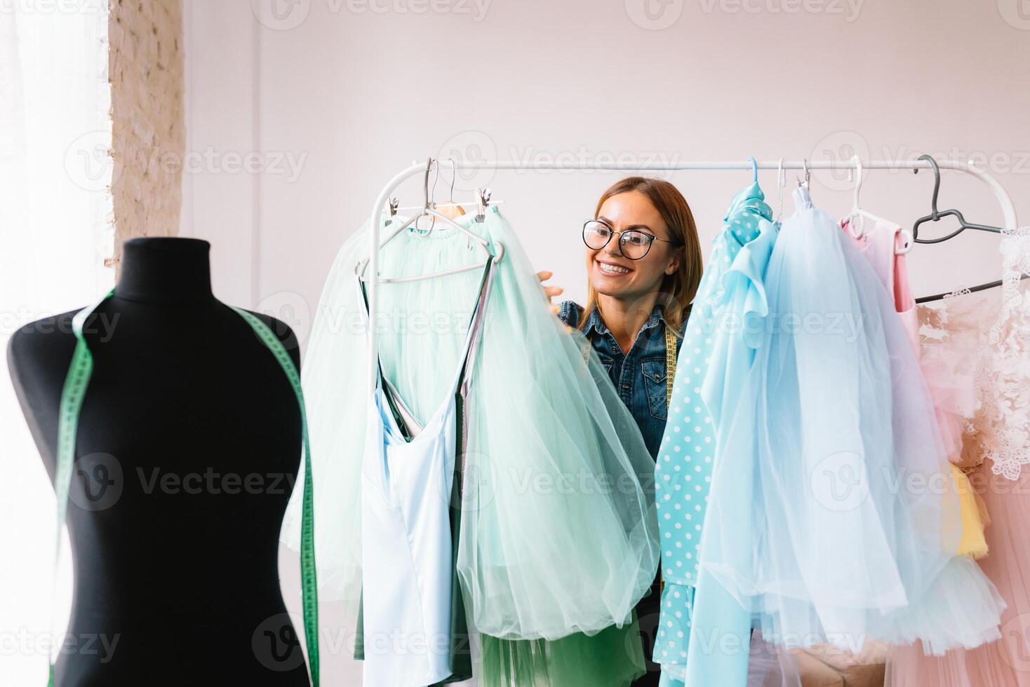 gelukkig ondernemer mode ontwerper in textiel bedrijf ontwerpen nieuw kleinhandel kleding verzameling. gelukkig werken vrouw naaister , ontwerper genieten werken Aan kleding stof schetsen. ondernemer concept foto