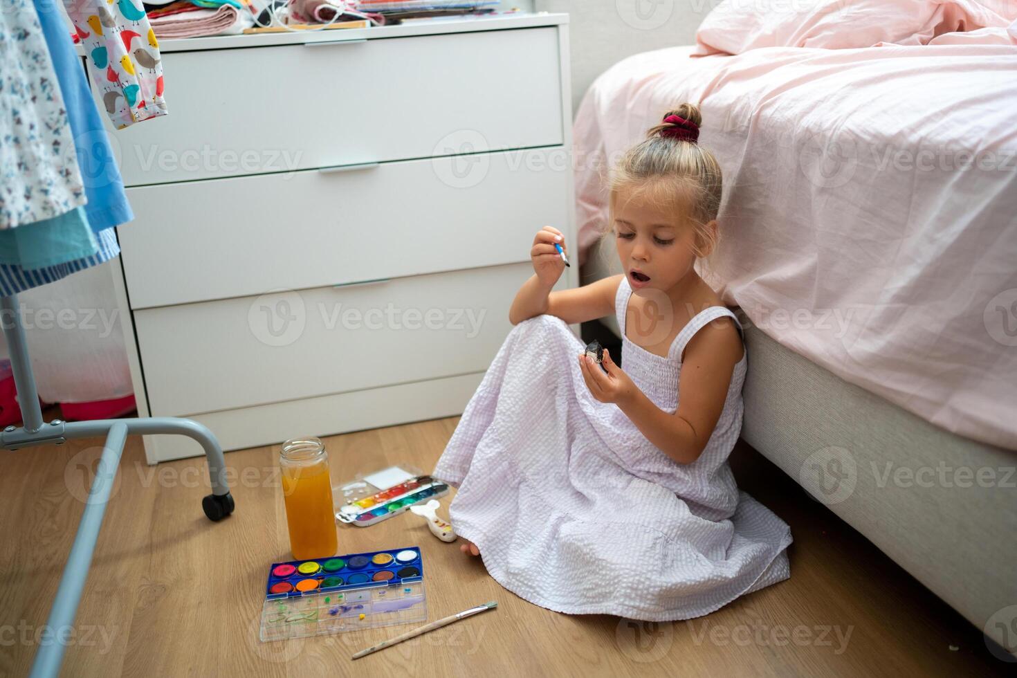 weinig meisje maken keramisch decor zittend verdieping foto