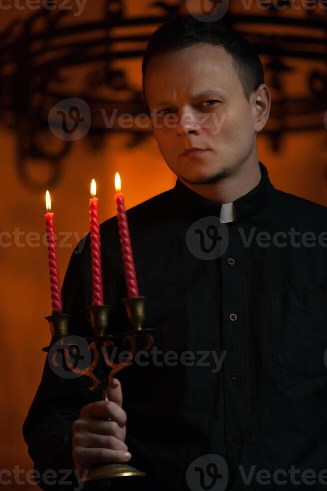 portret van knap Katholiek priester of voorganger met hond halsband, donker rood achtergrond. foto