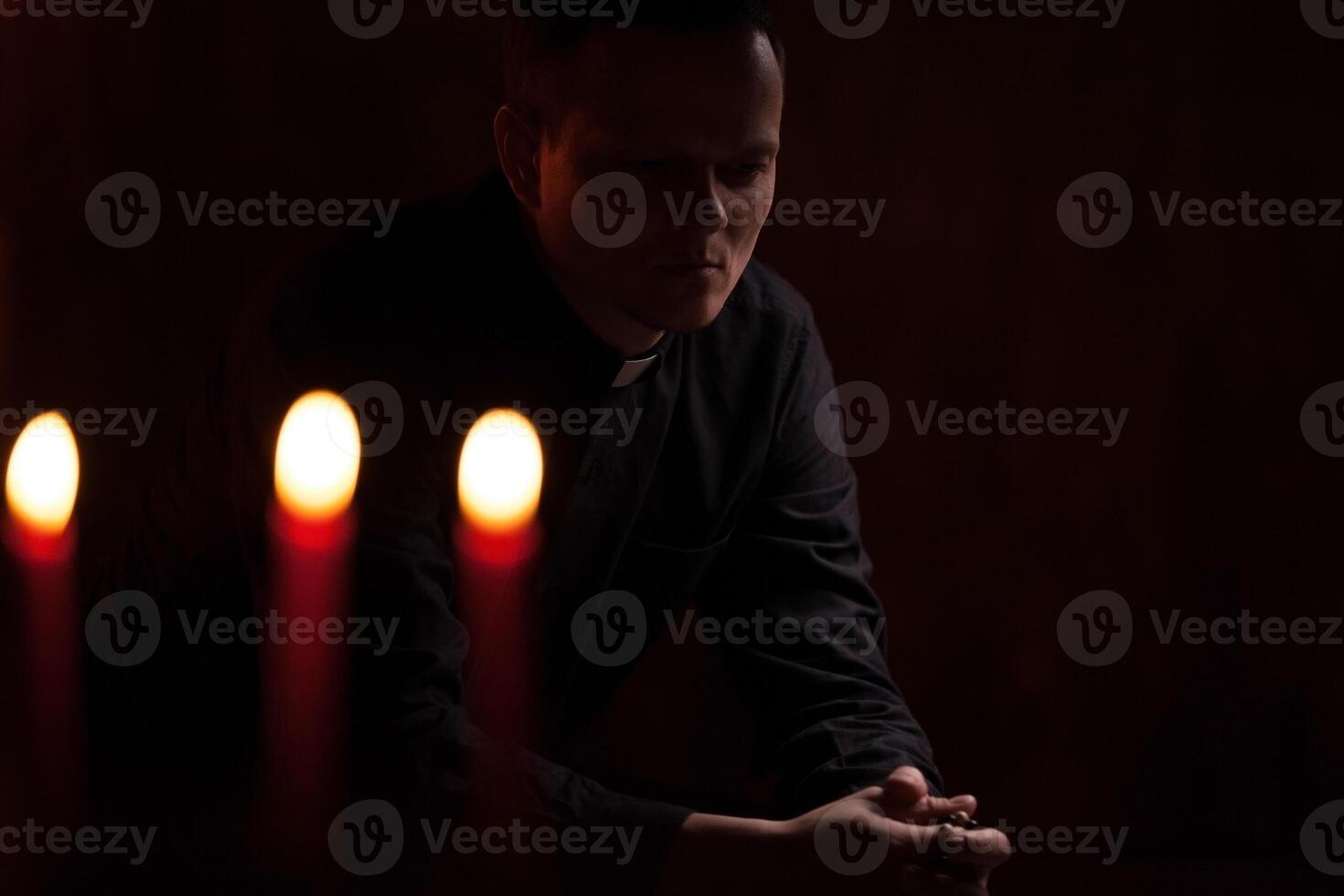 portret van knap Katholiek priester of voorganger met hond halsband, donker rood achtergrond. foto