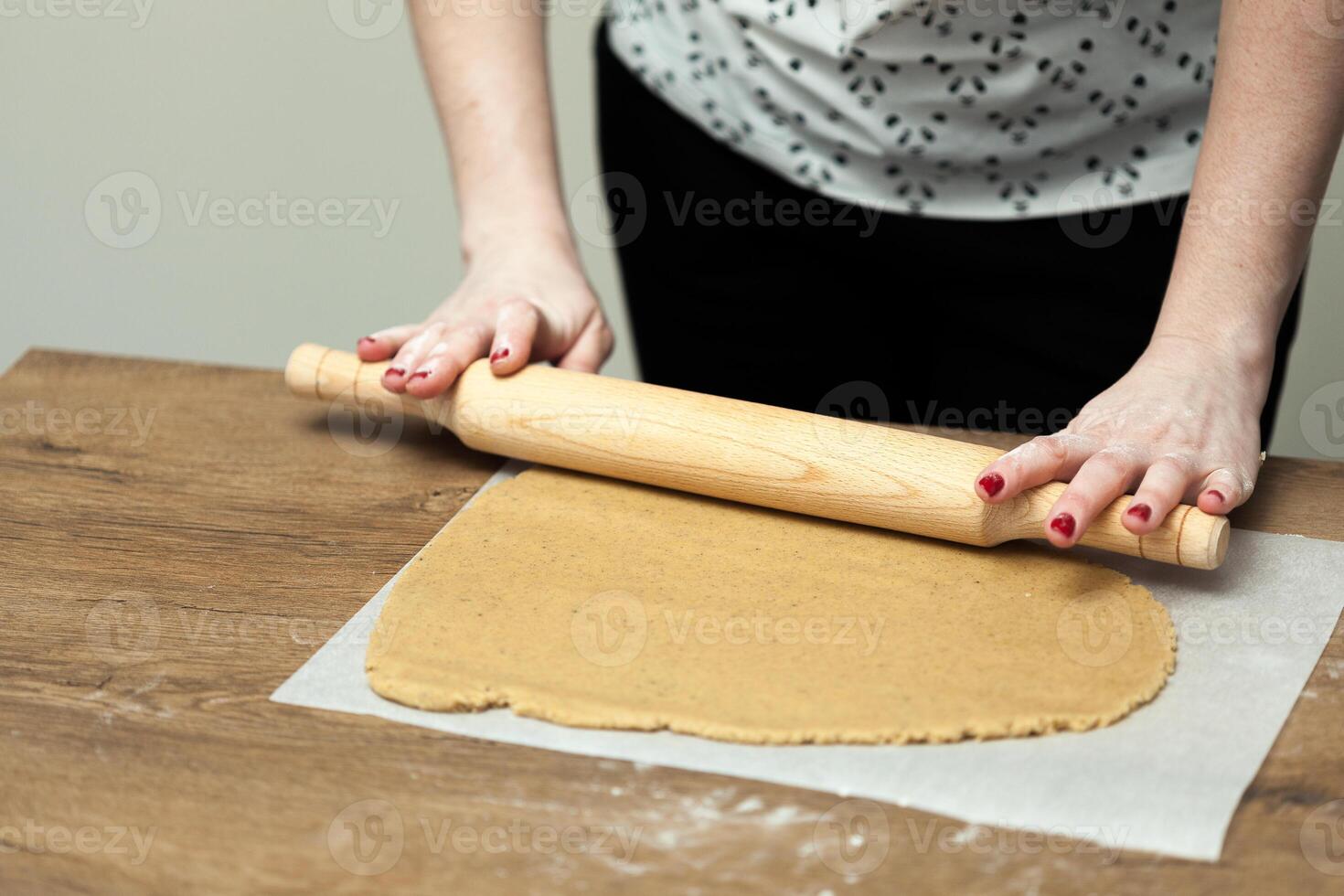 handen rollend deeg voor peperkoek Aan de houten tafel foto