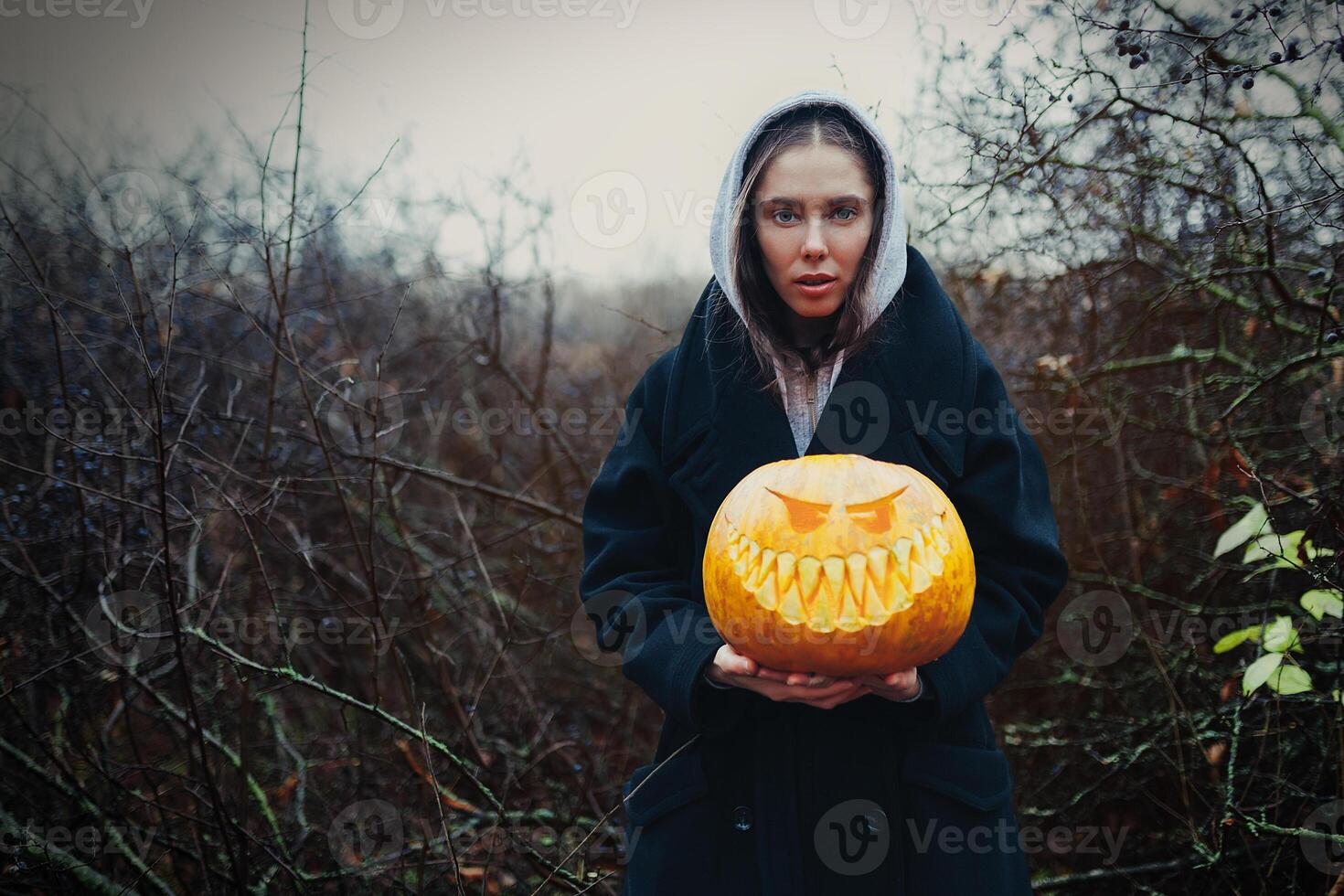 jong vrouw Holding de halloween pompoen in de herfst achtergrond foto