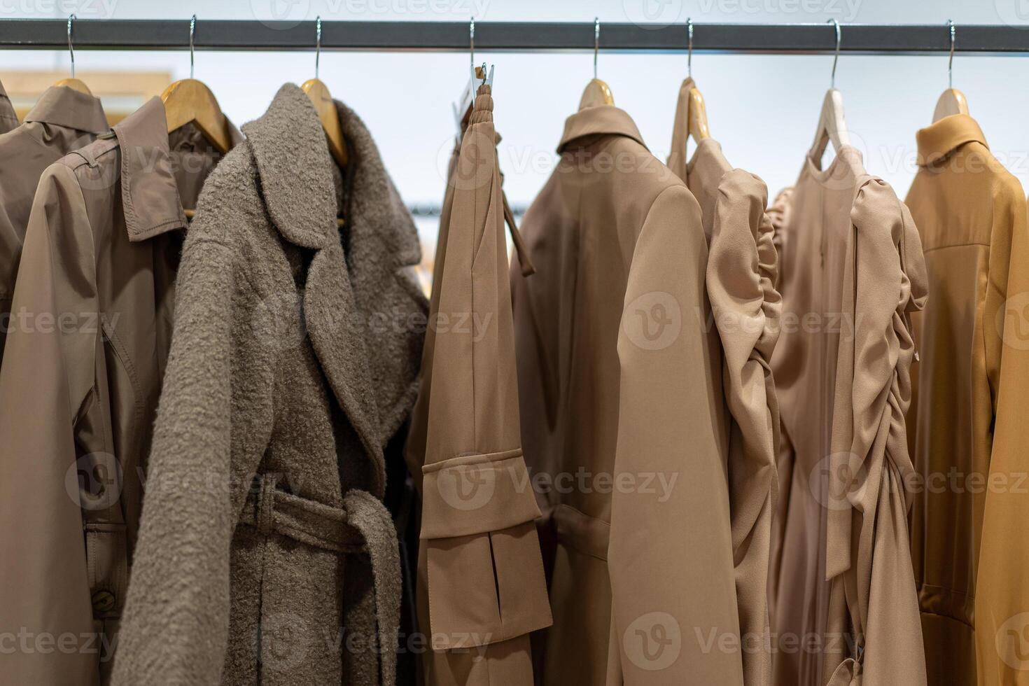 pastel kleding overhemden hangen Aan hangers in een winkel achtergrond. een verscheidenheid van kleren hangende in de garderobe. foto