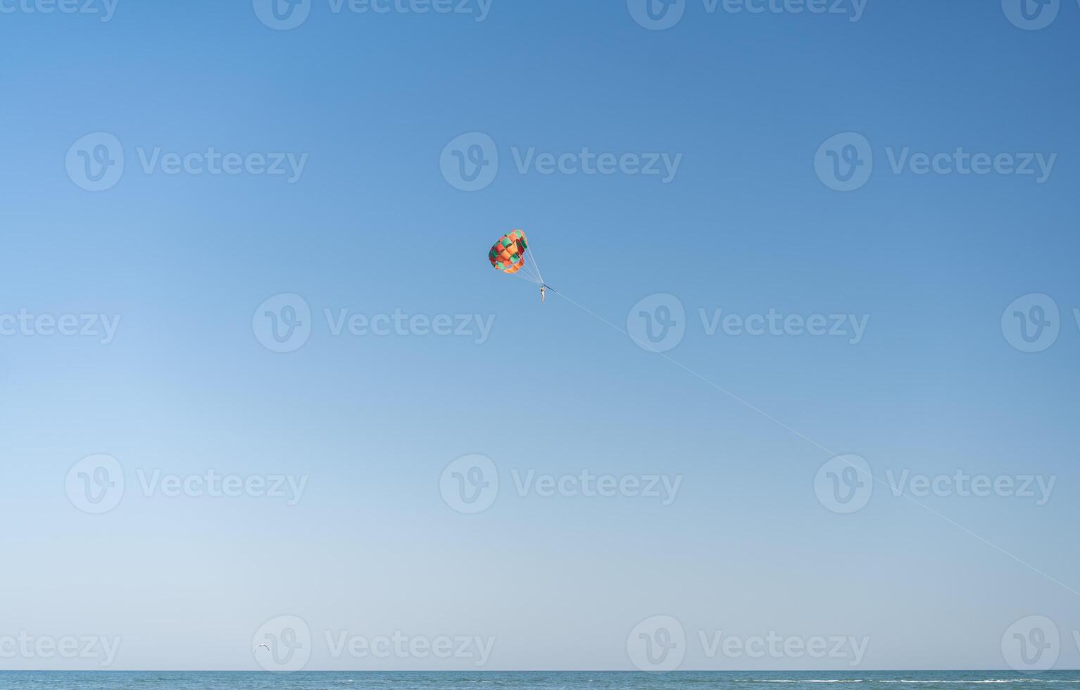 vlieg met kleurrijk parachute Bij de strand. foto