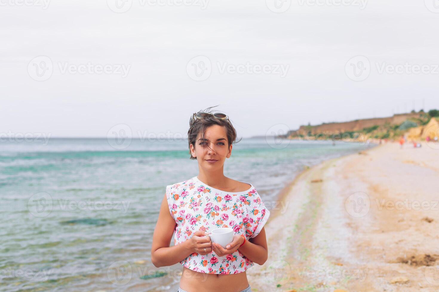 mooi vrouw kom tot rust gedurende exotisch vakantie Aan de strand genieten van zoet koffie foto