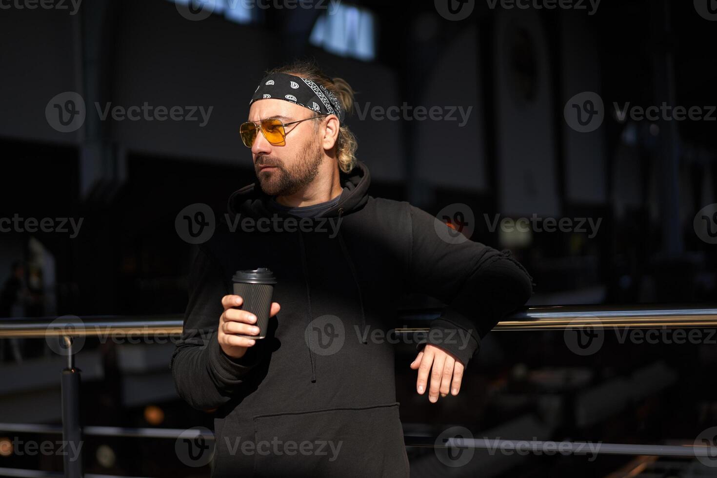 knap jong ongeschoren Mens zwart capuchon en bandana staat foto