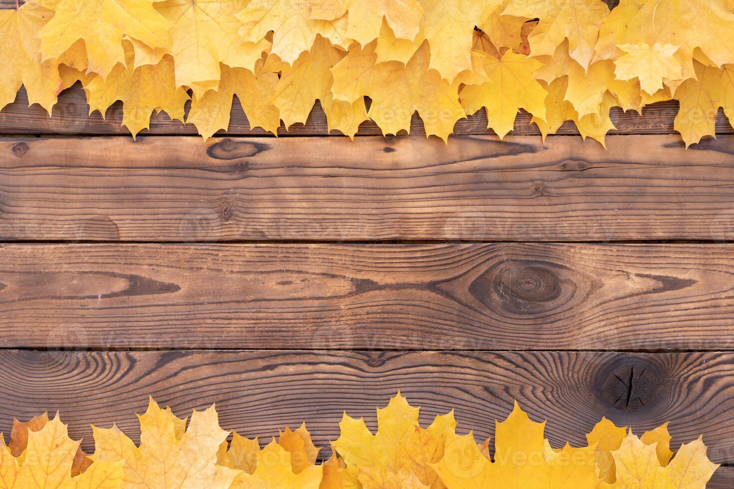 herfst bladeren kader Aan houten achtergrond top visie vallen grens geel en oranje bladeren wijnoogst hout tafel kopiëren ruimte voor tekst. foto