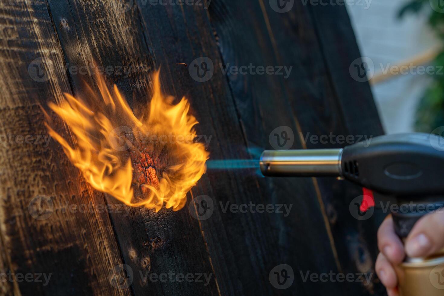 professioneel timmerman gebruik makend van oud traditioneel Japans techniek. brandend hout planken met gas- brander foto