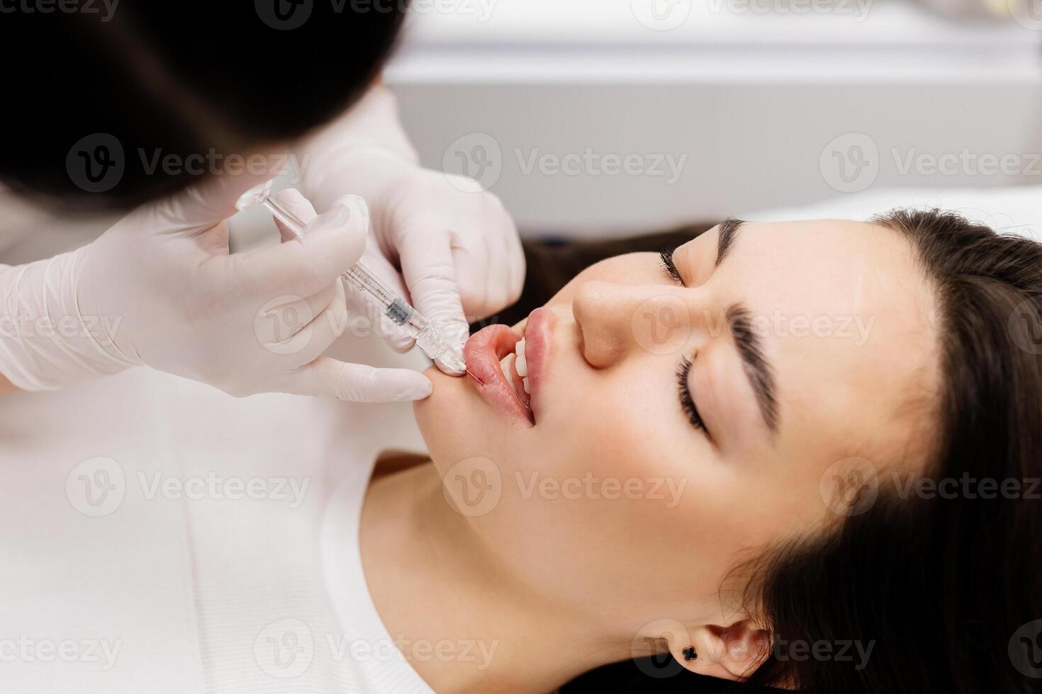 de dokter schoonheidsspecialist maakt lip vergroting procedure van een mooi vrouw in een schoonheid salon.cosmetologie huid zorg. hoog kwaliteit foto