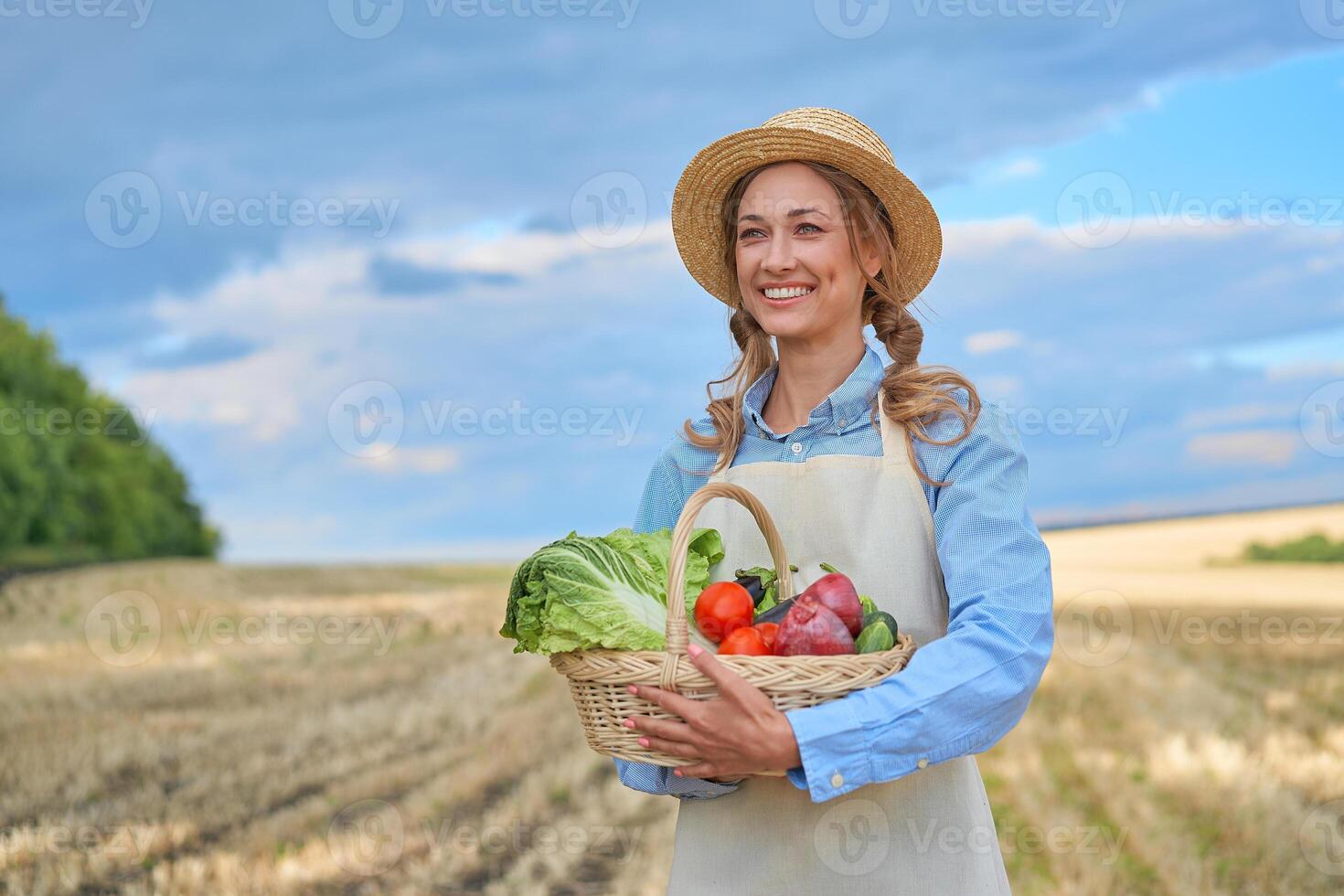 vrouw boer rietje hoed schort staand bouwland glimlachen vrouw agronoom specialist landbouw agribusiness gelukkig positief Kaukasisch arbeider agrarisch veld- foto