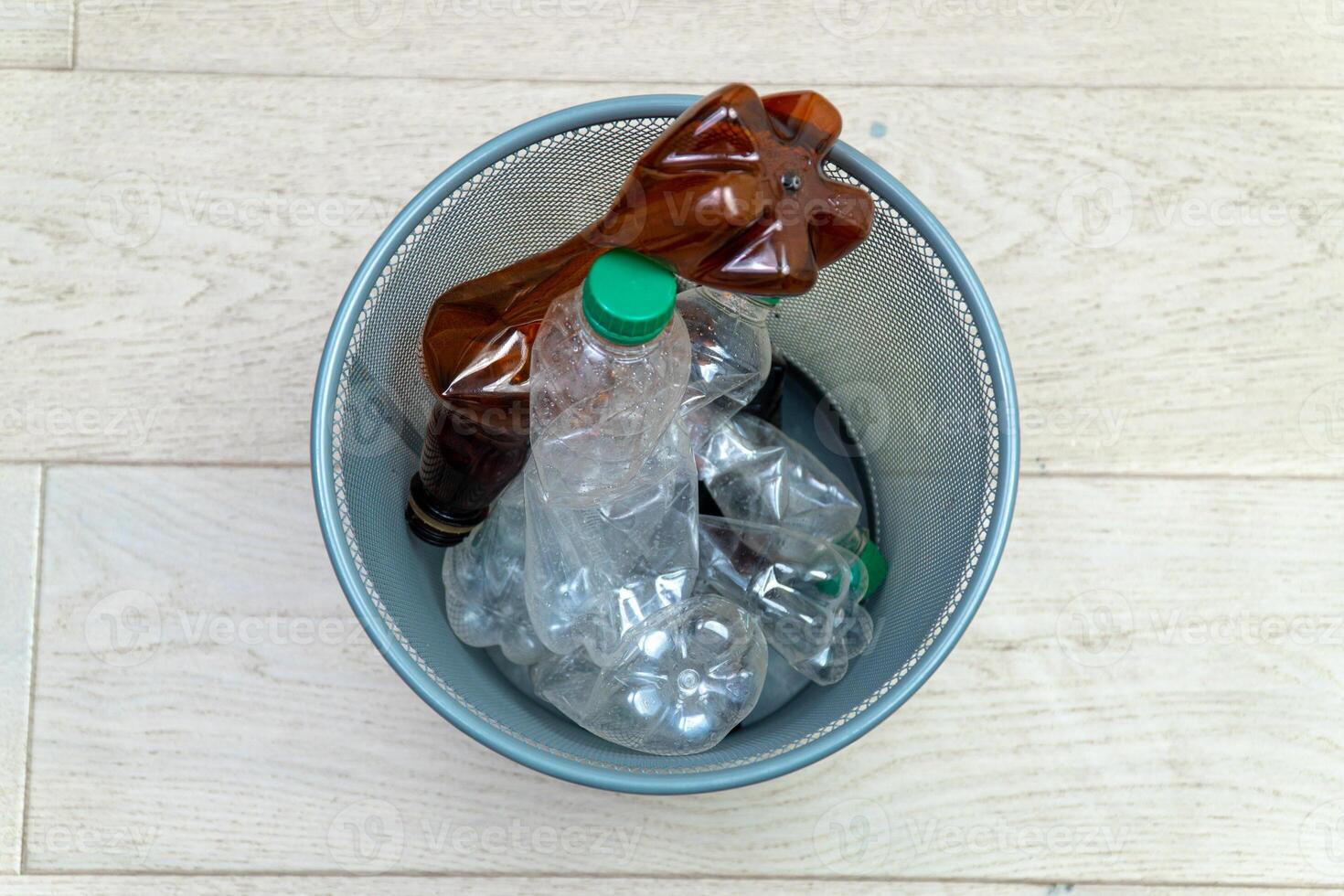 vijf verschillend plastic flessen in de kantoor uitschot kan. ecologie en recycling van verspilling van divers rauw materialen foto