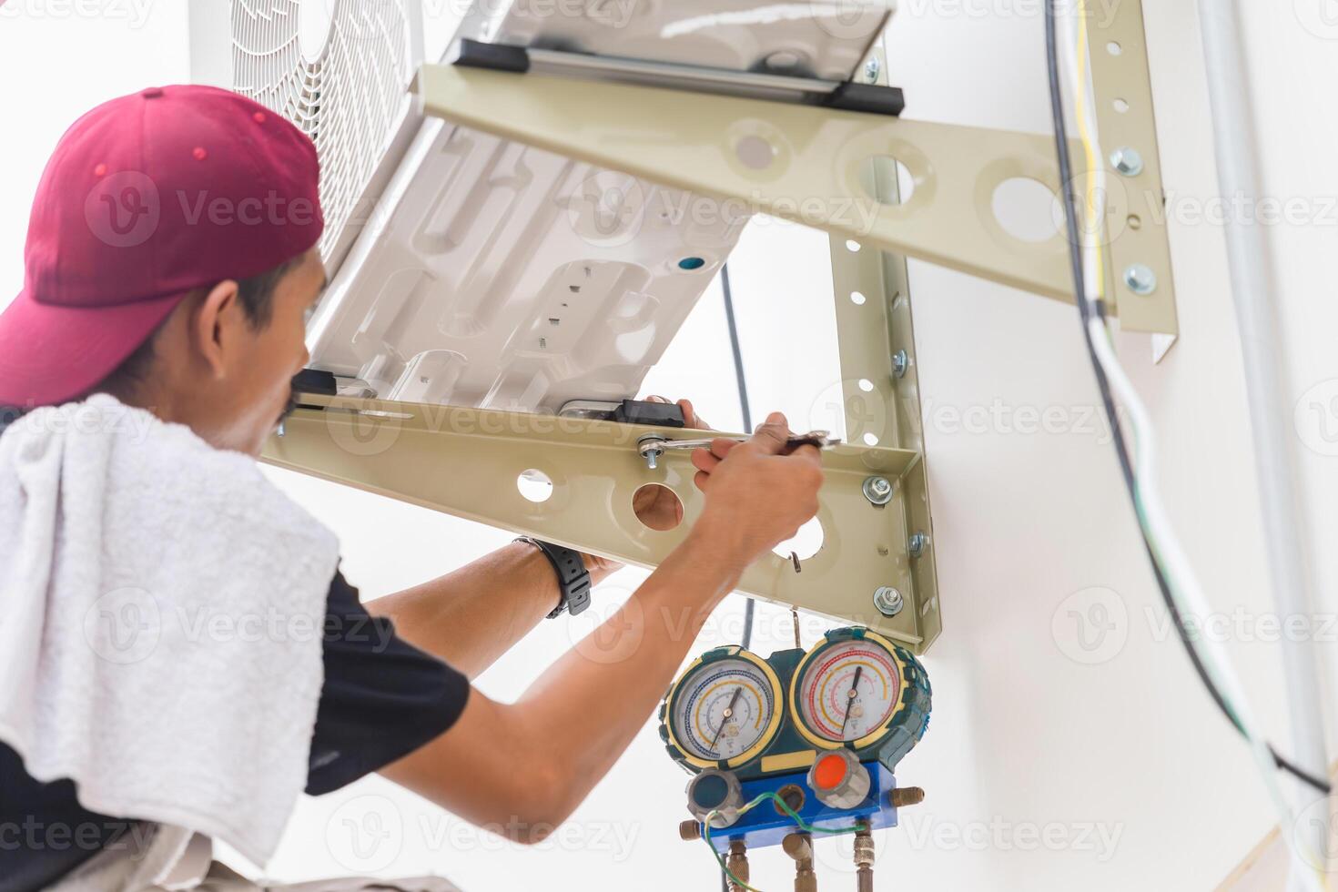 technicus Mens gebruik makend van een moersleutel naar fix en installeren nieuw lucht conditioner, mannetje technicus onderhoud voor reparatie en onderhoud van lucht conditioners foto