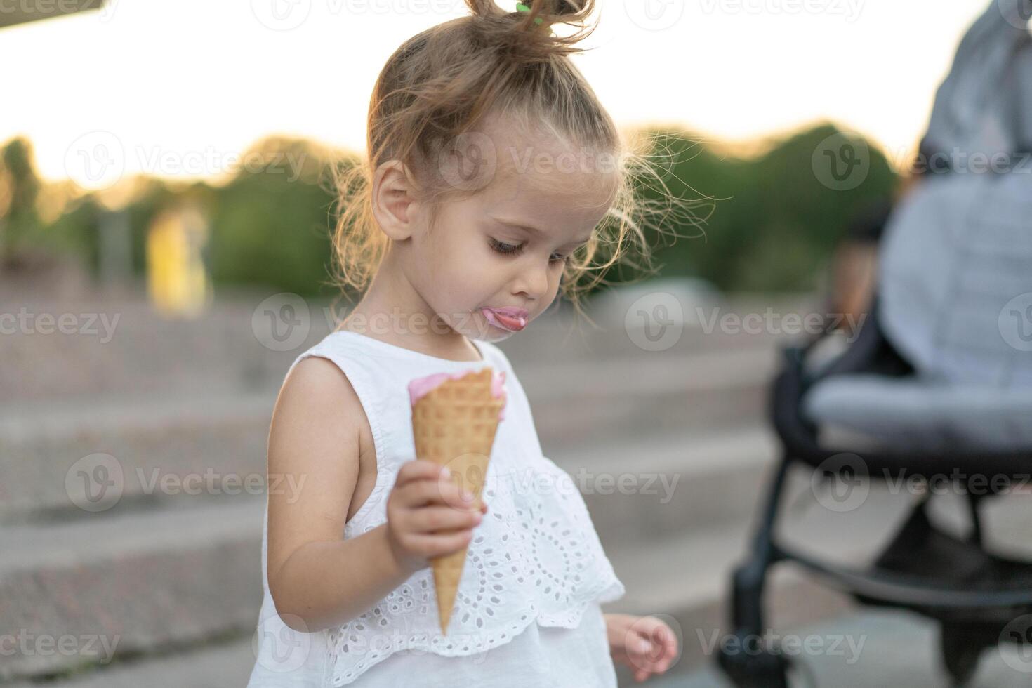 weinig Kaukasisch meisje 3 jaren oud eet ijs room detailopname portret foto