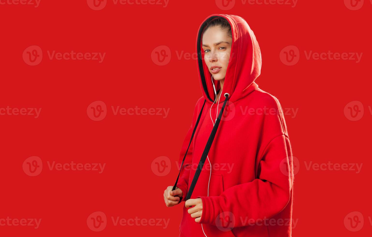 mooi Kaukasisch sportief vrouw naar modieus rood capuchon foto