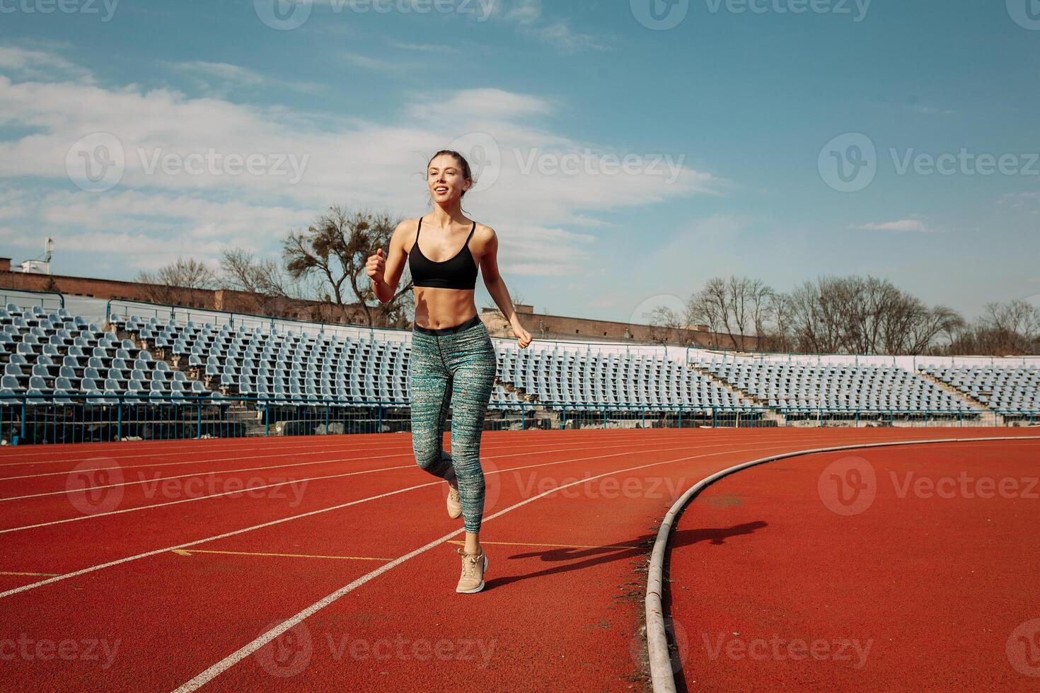 een mooi jong gemengd ras meisje is rennen langs een loopband Bij de stadion. de concept van een gezond levensstijl en verliezende gewicht foto