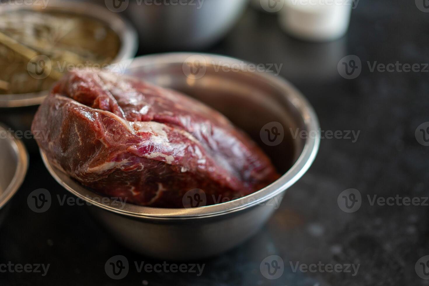 een groot sappig stuk van rundvlees vlees leugens in een metaal bord Aan een tafel foto