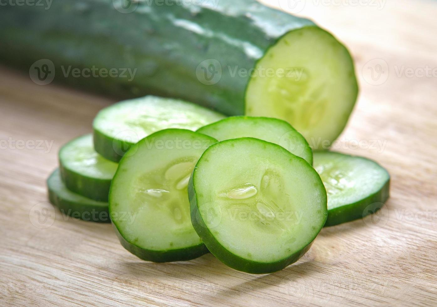verse plakjes komkommer op hout achtergrond foto
