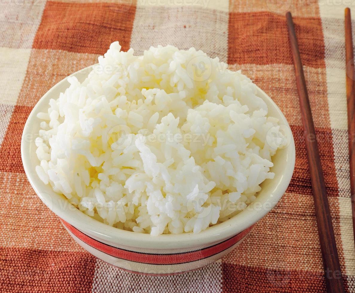 rijst in een kom op een witte achtergrond foto