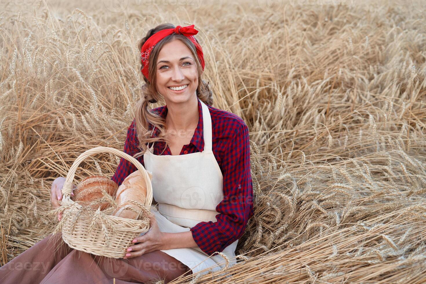 vrouw boer zittend tarwe agrarisch veld- vrouw bakker Holding rieten mand brood Product foto