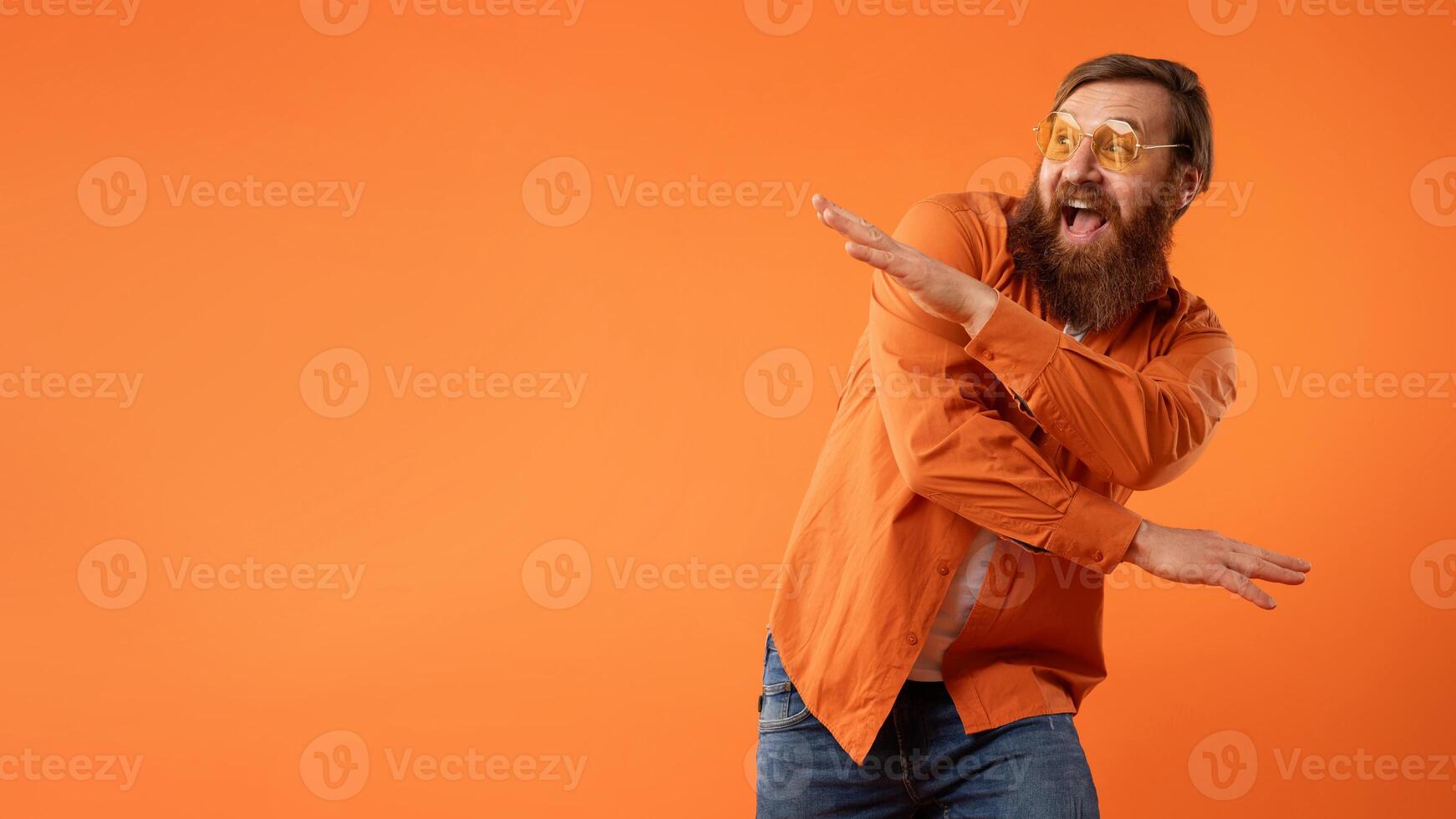 roodharige gebaard vent in zonnebril dansen met grappig beweegt, studio foto