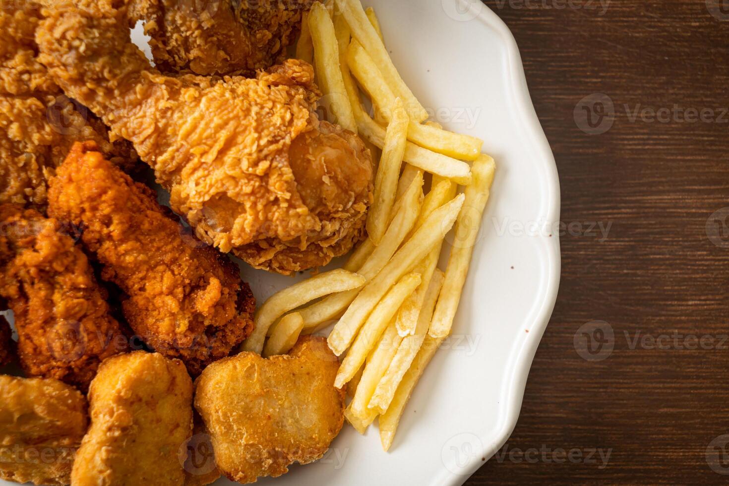 gebakken kip met frietjes en nuggets op bord foto