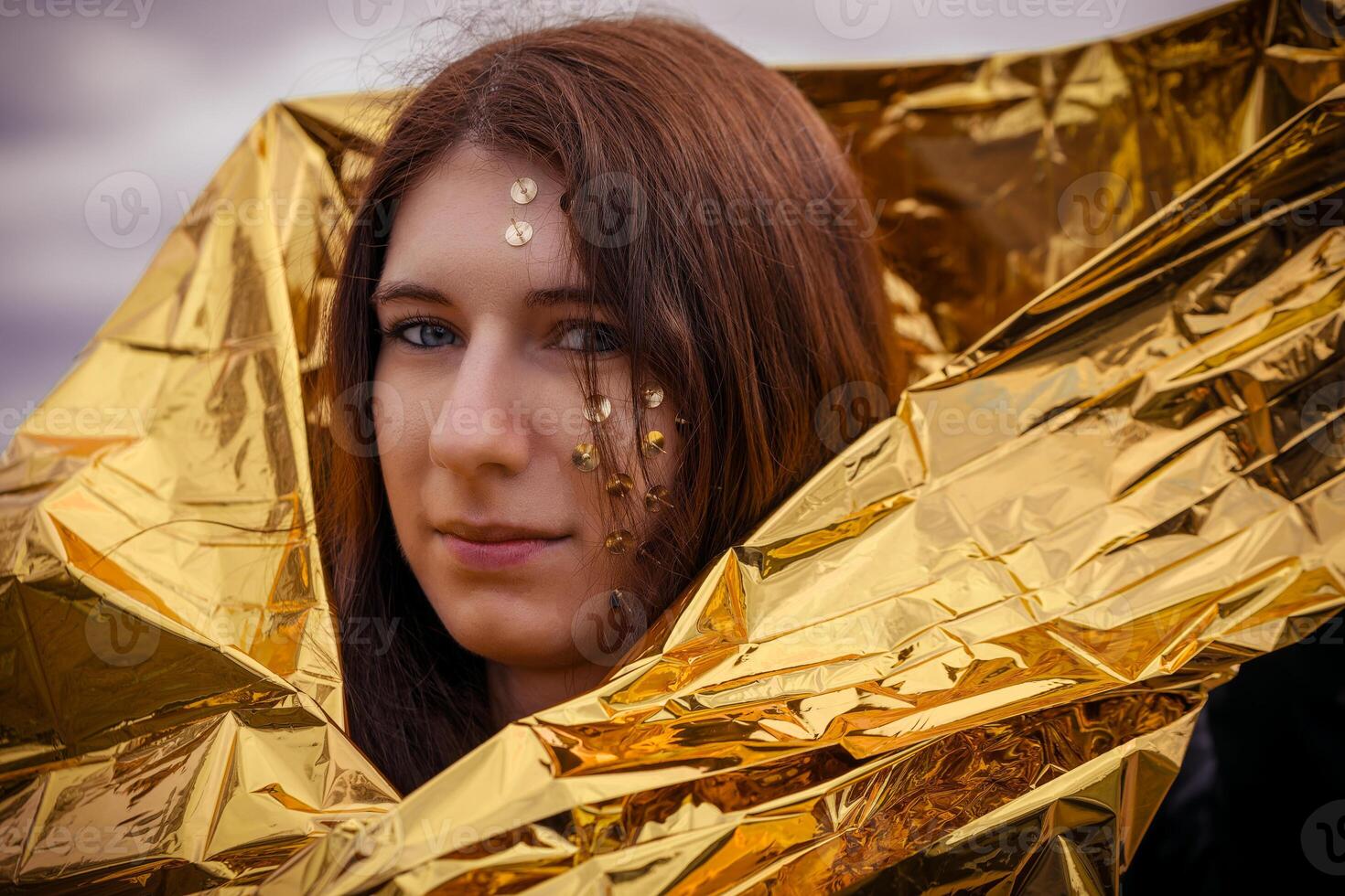 vrouw net zo een fantasie vertegenwoordiging met kopspijkers in haar gezicht en een gouden redden deken foto