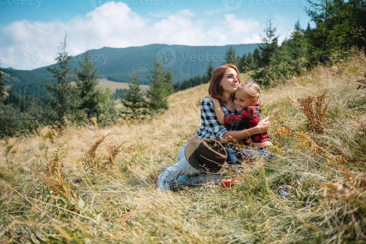 mam knuffels een weinig zoon Bij de top van de berg. vierkant. de concept van familie, yoga, reizen. foto