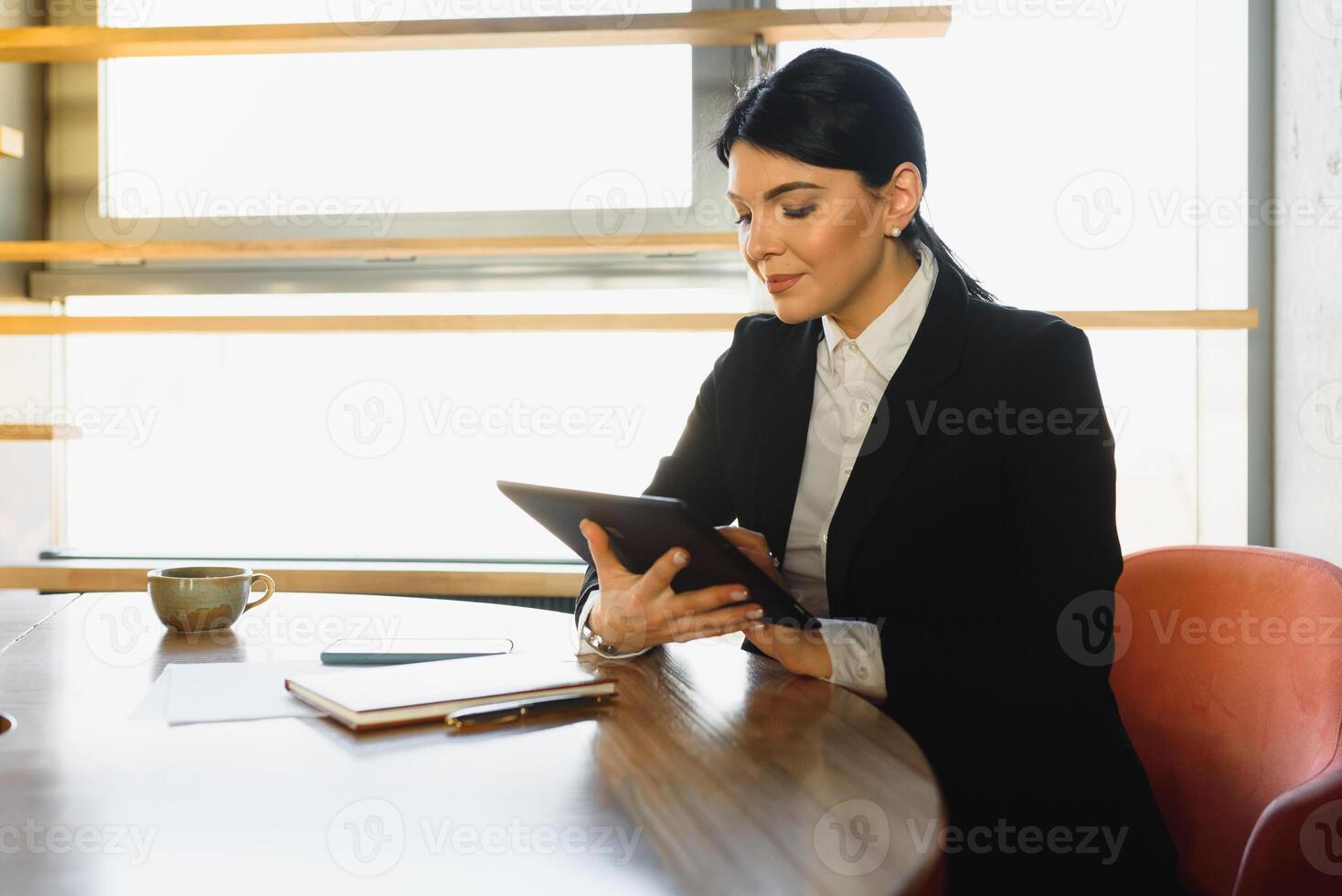 portret van een elegant zakenvrouw gebruik makend van tablet pc in een helder modern kantoor foto