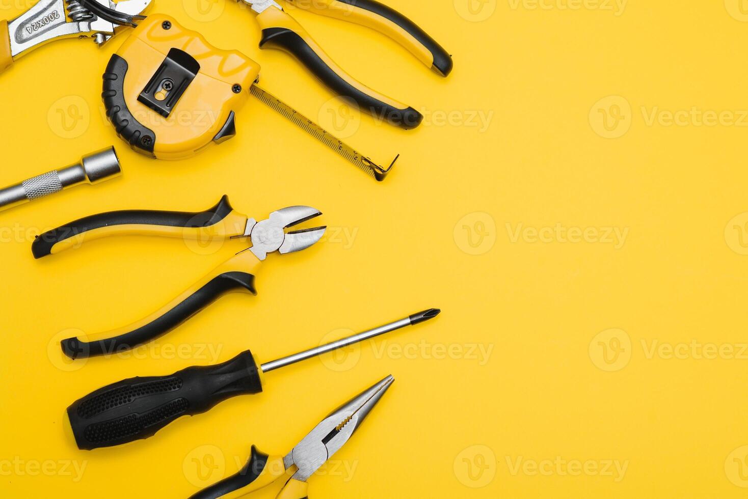 geel en zwart handig gereedschap heimachines en schroevedraaier geïsoleerd Aan geel achtergrond. foto