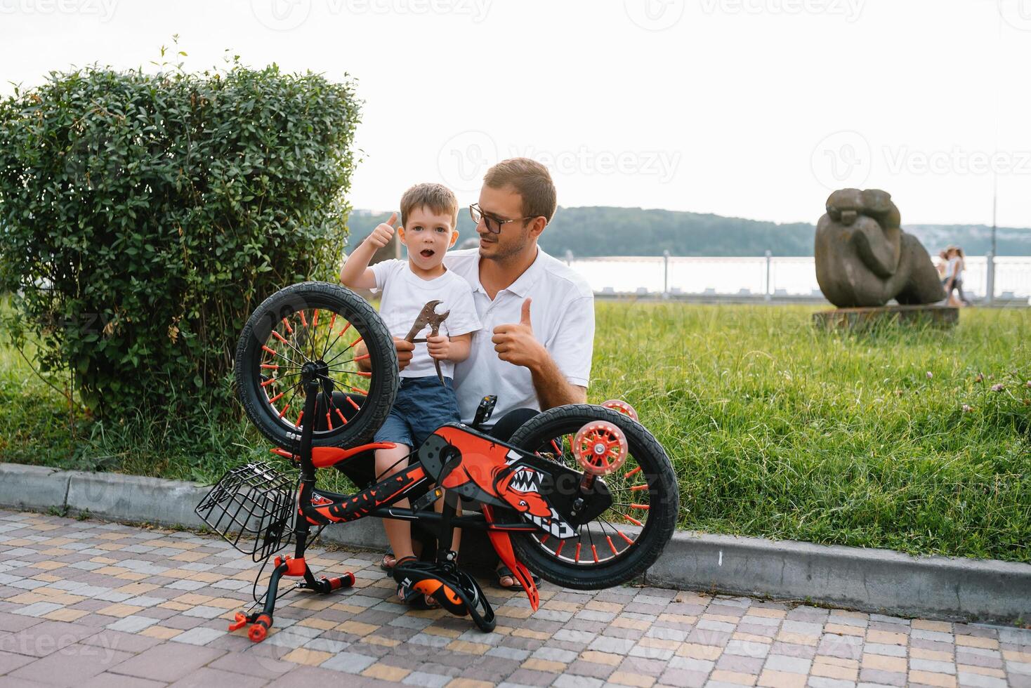 gelukkig vader en zijn zoon hebben pret samen Bij de groen park, vaststelling fiets samen. vader dag. foto