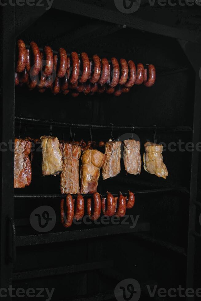 gerookt traditioneel gerookt vlees. een samenstelling van gerookt verkoudheid bezuinigingen Aan een zwart achtergrond. foto