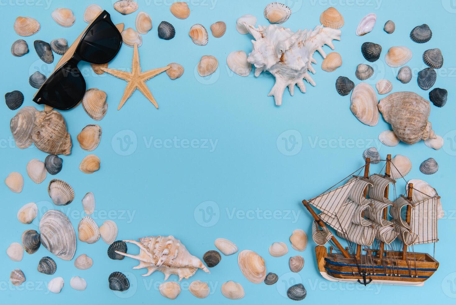 vlak leggen. top visie. kader van schelpen van divers soorten Aan een blauw achtergrond. schelpen en zeester en schip Aan een pastel achtergrond. vakantie concept. reizen concept. met kopiëren ruimte foto