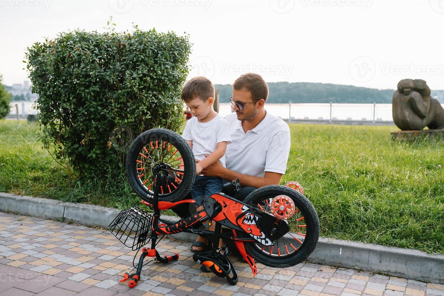 gelukkig vader en zijn zoon hebben pret samen Bij de groen park, vaststelling fiets samen. vader dag. foto