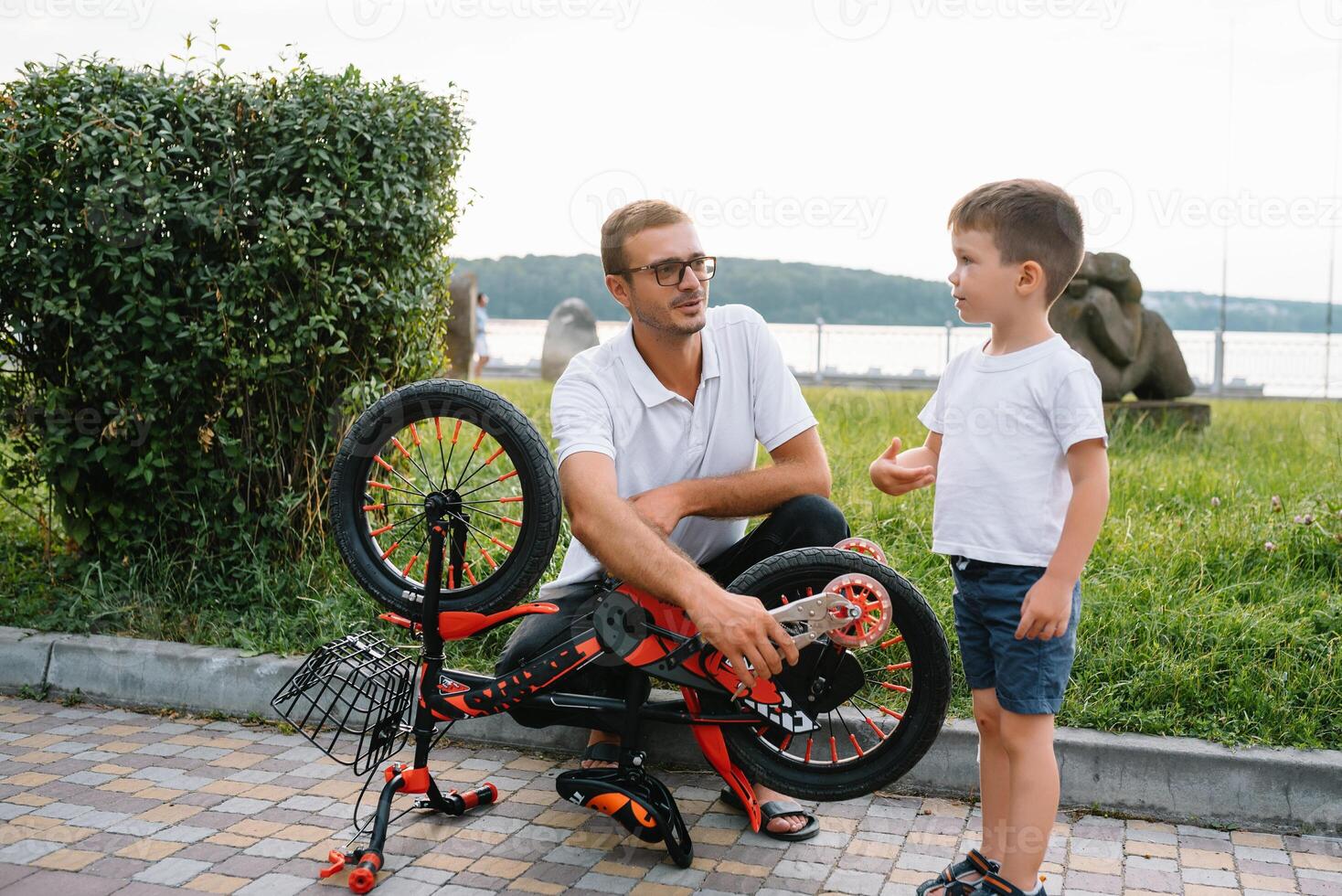 gelukkig vader en zijn zoon hebben pret samen Bij de groen park, vaststelling fiets samen. vader dag. foto