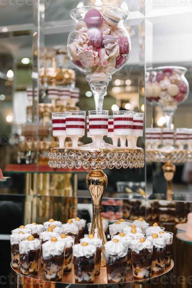 heerlijk bruiloft ontvangst snoep bar toetje tafel. bitterkoekjes Aan snoep bar, snoep bar Aan vakantie, snoep bar Bij de bruiloft. foto