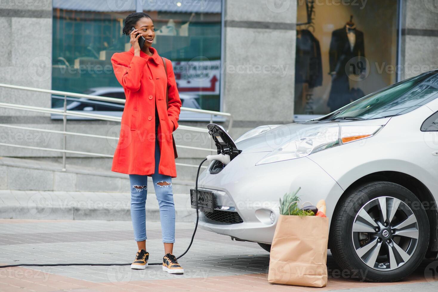 opladen elektro auto Bij de elektrisch gas- station. vrouw staand door de auto. dame met levensmiddel foto