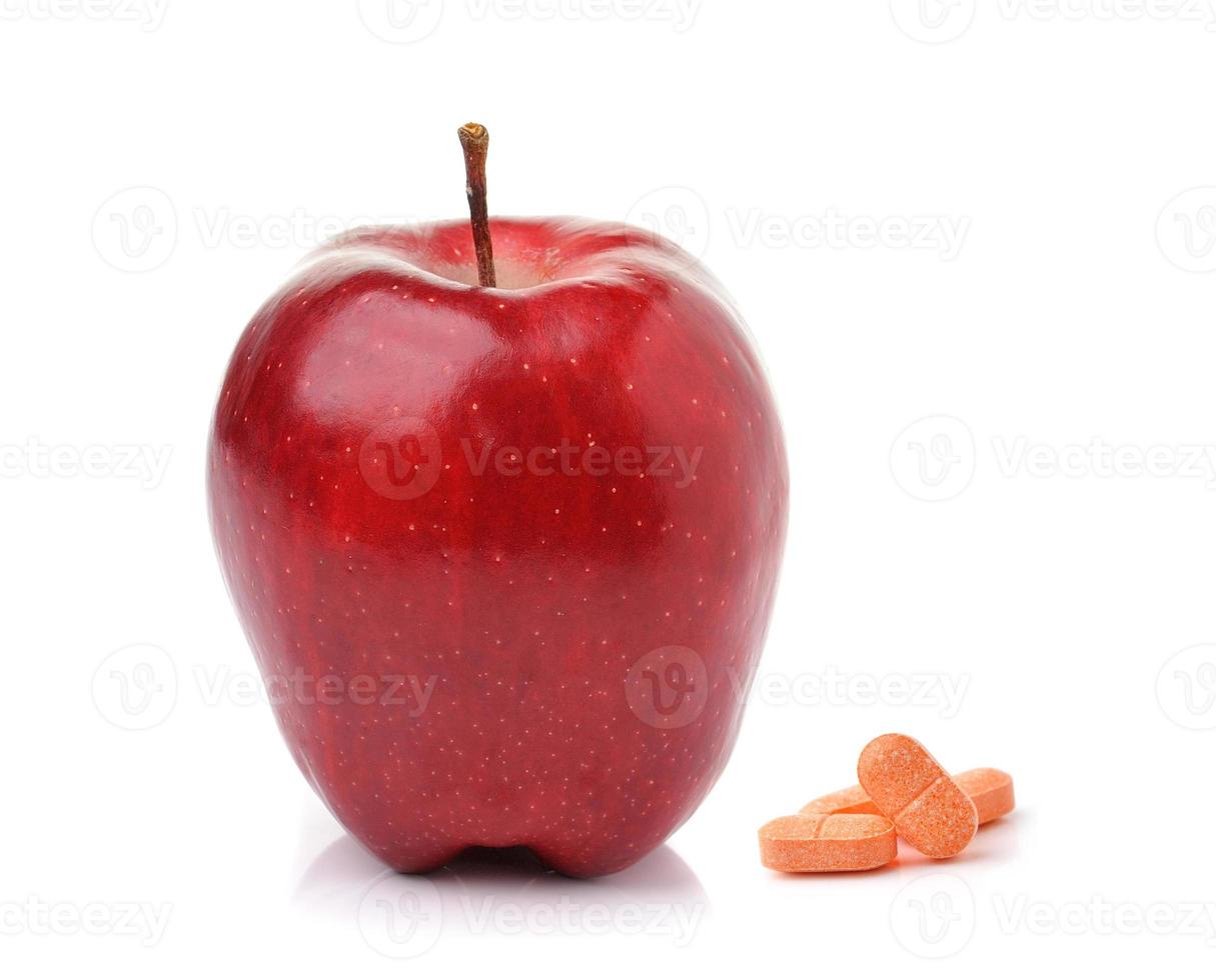 Rode rijpe appel en pillencapsules die op witte achtergrond worden geïsoleerd foto