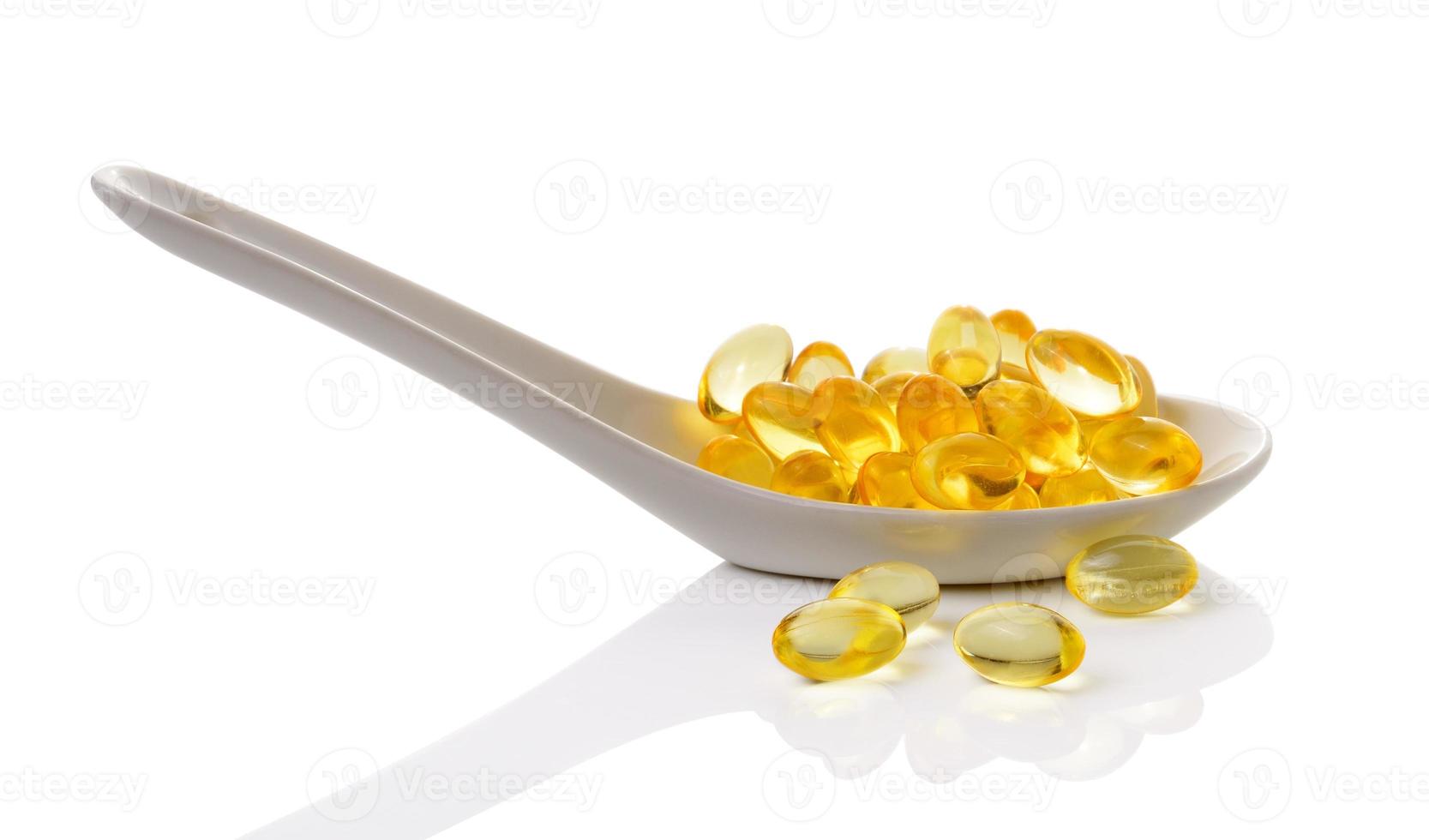 kabeljauwleverolie omega 3 gelcapsules in lepel op witte achtergrond foto